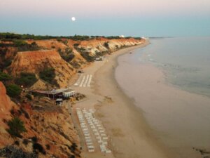 Blick auf die rote Felsküste der Algarve bei Sonnenuntergang