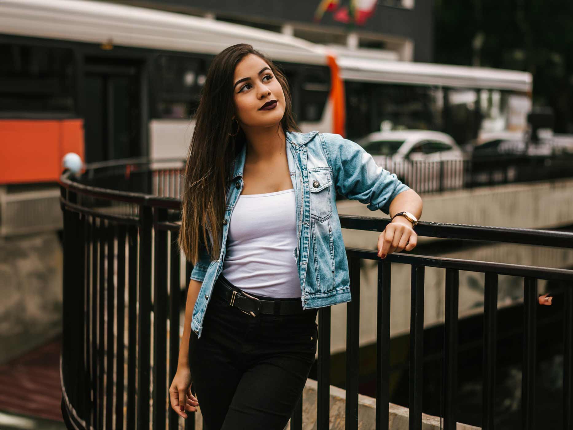 Frau trägt weißes Top, blaue Jeansjacke und schwarze Jeans