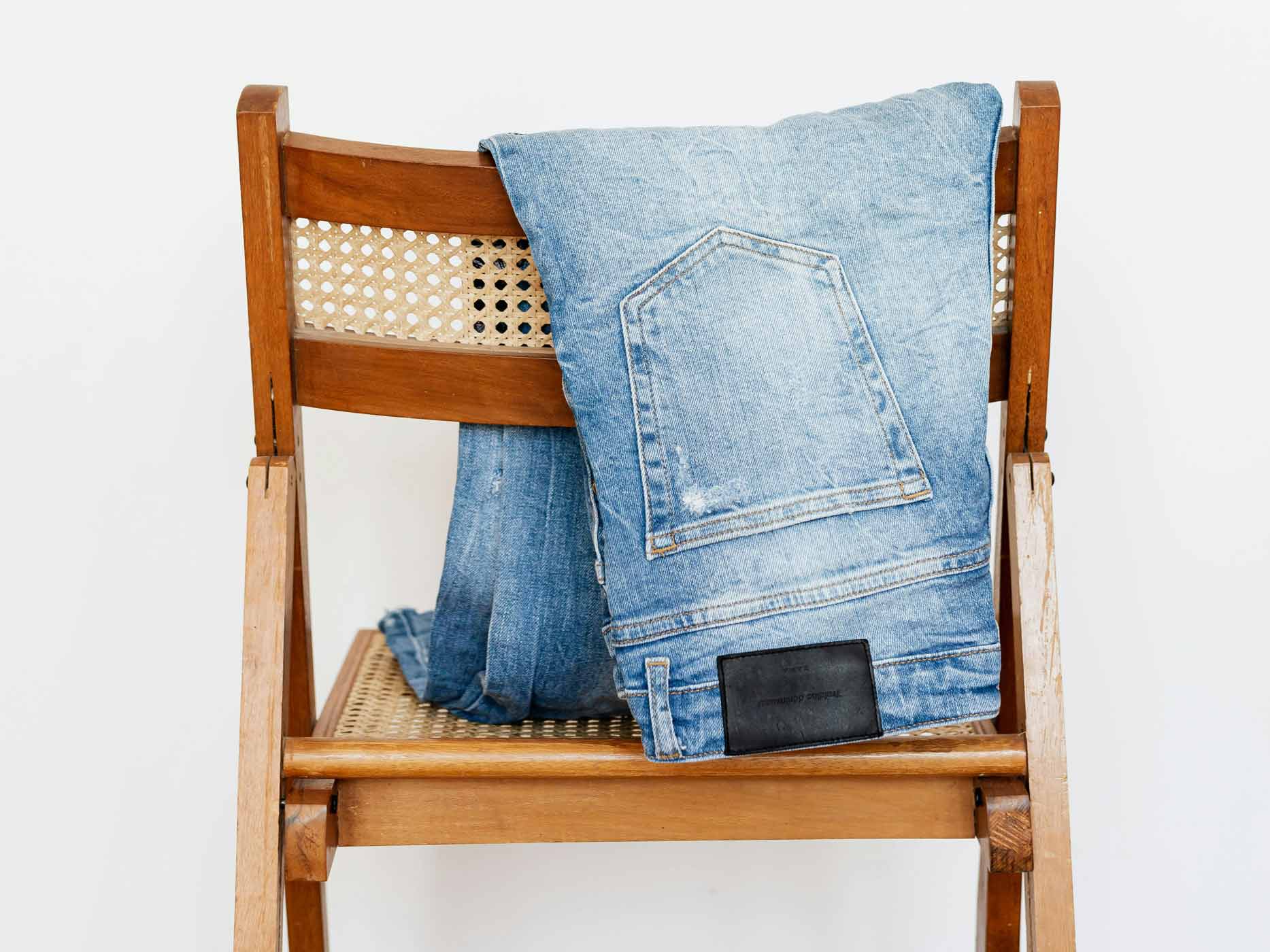 Eine Jeanshose hängt über einem Stuhl